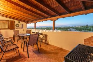 a room with a balcony with a table and chairs at Luxury appartment, only 7 minutes from Thessaloniki airport and 15 minutes from city center ,for 8-23 people also for gatherings and parties in Néon Rýsion