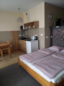 a bedroom with two beds and a small kitchen at Apartamenty JAGA parking, FVAT in Kielce