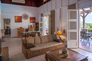 a living room with a couch and a table at TI'BAKOUA in Les Anses-dʼArlets