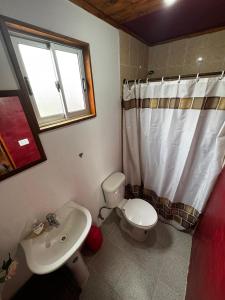 Un baño con un inodoro blanco y un lavabo. en proteas, en Pichilemu 3 fotos más