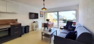a living room with a blue couch and a table at Appartement Reve Marin in Saint-Pierre-Quiberon