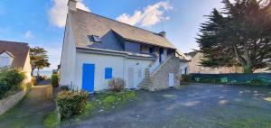a white house with blue doors and a driveway at Appartement Reve Marin in Saint-Pierre-Quiberon