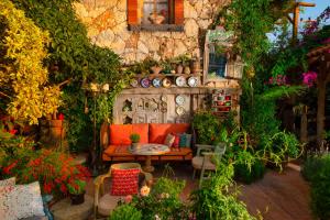a garden with a couch and a table and plants at Fidanka Hotel in Kalkan