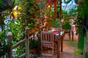a table and chairs in a garden with plants at Fidanka Hotel in Kalkan