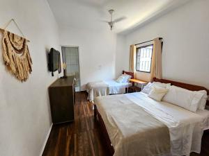 Una habitación de hotel con dos camas y un televisor. en Casa perto do Parque dos Saltos - Brotas - Casa 3, en Brotas