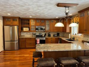 a kitchen with wooden cabinets and stainless steel appliances at Adirondack Luxury Getaway in Eagle Bay