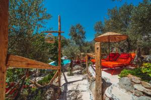a patio with two chairs and an umbrella at Fidanka Hotel in Kalkan