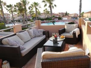 un patio con divani, tavolo e piscina di Preciosa casa con terraza y piscina R64 by Novadesta a Gran Alacant