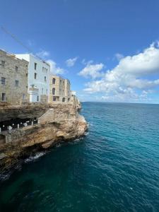 a building on a cliff next to the ocean at villa lanterna in Conversano