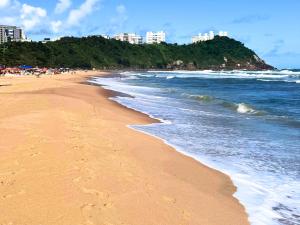 a beach with footprints in the sand and the ocean at Tombo Beach in Guarujá