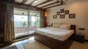a bedroom with a bed and a large window at Secret Garden by The StayCationer in Dehradun