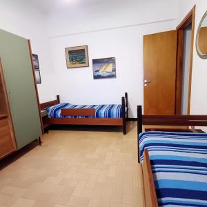 a room with two beds and a door at Diana Cosy Apartment sea view near the beach in Monterosso al Mare