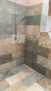 een badkamer met douche met een stenen muur bij A casa di Leia in Borgo