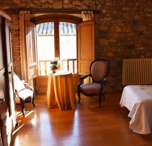 a room with a bed and a table and a window at Hotel Rural CHOUSA VERDE in Vegacervera +64 photos