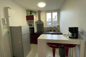 een keuken met een witte bar en een koelkast bij Le Baheux Urbain in Le Havre