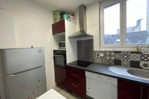 een keuken met een koelkast, een wastafel en een raam bij Le Baheux Urbain in Le Havre