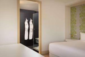 een slaapkamer met een kast met 2 bedden en een spiegel bij NH Amsterdam Zuid in Amsterdam