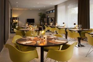 een eetkamer met tafels en gele stoelen bij NH Amsterdam Zuid in Amsterdam