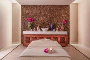 a bedroom with two beds and a table with flowers at Tivoli Carvoeiro in Carvoeiro