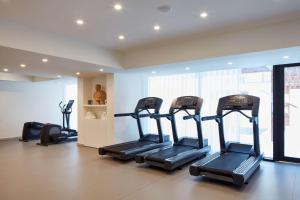 a gym with several treadmills in a room at Tivoli Carvoeiro in Carvoeiro