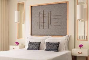 a bedroom with a white bed with two pillows at Tivoli Carvoeiro in Carvoeiro
