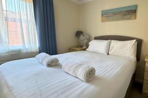 a bedroom with a white bed with towels on it at Family Friendly Lodge sleeping 5 with Hot Tub - Devon in Chudleigh +57 photos
