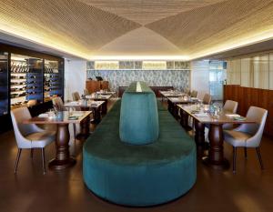 a restaurant with tables and chairs and a large green ottoman at Tivoli Carvoeiro in Carvoeiro