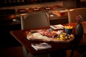 a piece of meat on a cutting board on a table at Tivoli Carvoeiro in Carvoeiro