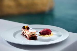 a white plate with two desserts on a table at Tivoli Carvoeiro in Carvoeiro