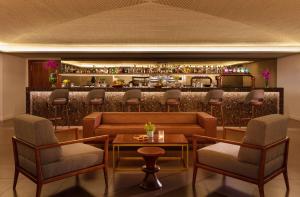a bar with chairs and a couch and a table at Tivoli Carvoeiro in Carvoeiro