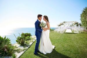 a bride and groom kissing in front of their wedding ceremony at Tivoli Carvoeiro in Carvoeiro