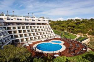 an external view of a hotel with a swimming pool at Tivoli Carvoeiro in Carvoeiro