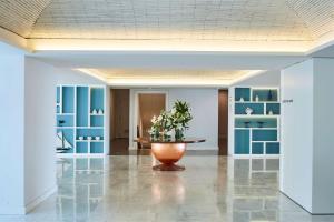 a lobby with a table and blue shelves at Tivoli Carvoeiro in Carvoeiro