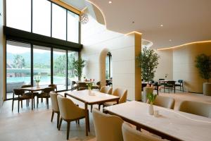 慕斯Viewpoint Khaoyai Hotel的有桌椅和大窗户的餐厅