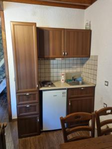 a kitchen with wooden cabinets and a white refrigerator at PS Attic Polydrosos - PS Rental in Polydrossos