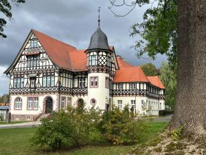 a large white building with a red roof at Ferienwohnungen Historische Post in Bad Liebenstein