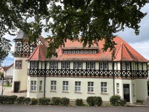 a large white building with a red roof at Ferienwohnungen Historische Post in Bad Liebenstein