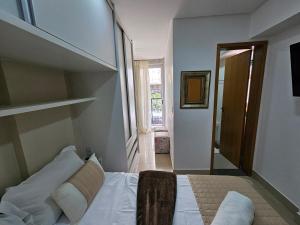 a bedroom with a bed in a room with a window at Lindissimo Flat 101 a uma esquina Flamboyant Shop in Goiânia