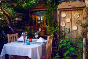 a table with a white table cloth and plates on a wall at Fidanka Hotel in Kalkan