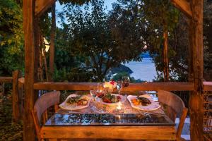 a table with two plates of food and glasses of wine at Fidanka Hotel in Kalkan