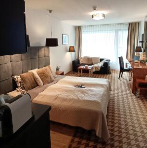 a bedroom with a large bed and a living room at 122 W PIĘCIOGWIAZDKOWYM ROYAL TULIP SAND 200m plaża DOBRUK APARTAMENTY ROMEK prywatny in Kołobrzeg
