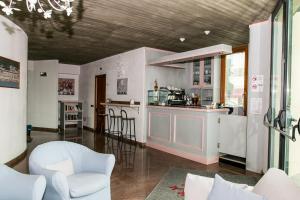 a kitchen with white cabinets and a bar with chairs at L'incanto Di Boccadarno in Marina di Pisa
