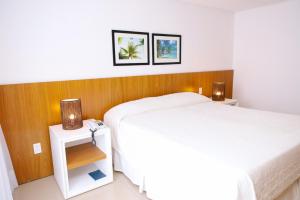 Cama ou camas em um quarto em Porto Suítes Natal Hotel