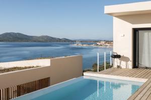 a house with a swimming pool and a view of the water at VILLA ARMONIA 3 bed family villa with private pool in Paleros