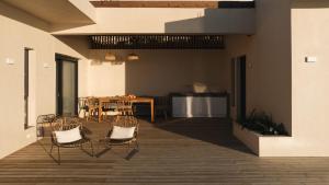 a patio with chairs and a table and a table and a dining room at VILLA ARMONIA 3 bed family villa with private pool in Paleros