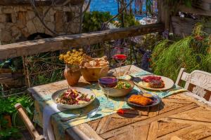a table with plates of food and glasses of wine at Fidanka Hotel in Kalkan