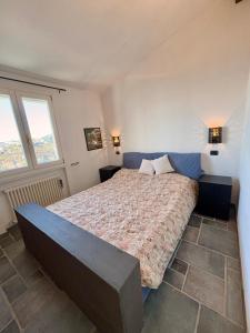 Un dormitorio con una cama grande con dos ventanas. en Casa Toto Brocchi, en San Remo