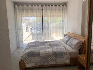 a bedroom with a bed in front of a window at Katerina in Ayia Napa