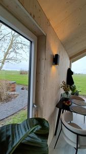 a room with a large window and a table and chairs at Boerenerf Lodge - Erf 1 in Kampen