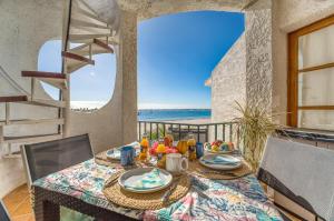 a dining table with a view of the ocean at Ideal Property Mallorca - Dali 127 in Port d'Alcudia